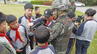 兵哥哥野外训练偶遇春游小学生 这样的互动太有爱了！