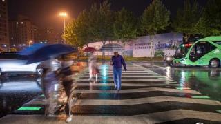 浙江金华：居民冒雨行走在绿色斑马线上