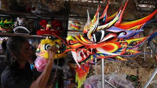 为迎接春节 印尼工人绘制龙狮面具