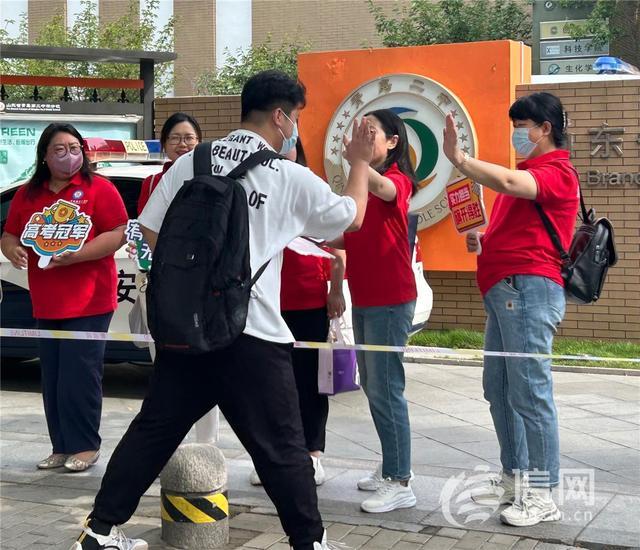 青岛送考老师排队与考生击掌送上祝福“高考冠军”