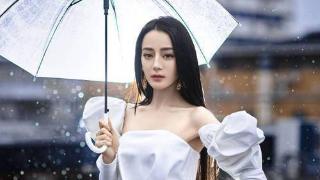 迪丽热巴雨中打着透明雨伞，一双修长的美腿让人大饱眼福