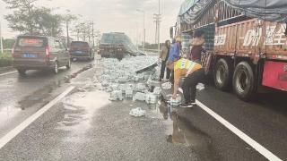 600多箱矿泉水散落路面 公路人冒雨清障保畅通