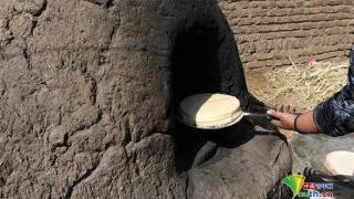埃及妇女用自制陶土烤箱烤面包