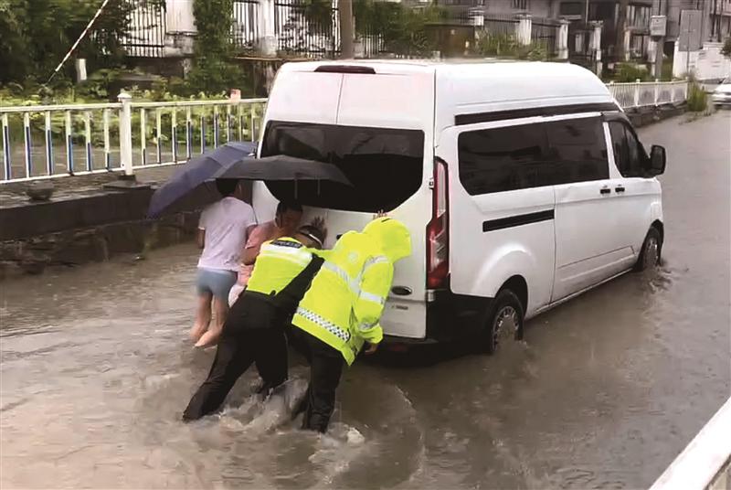 暴雨致车抛锚 交警涉水推车