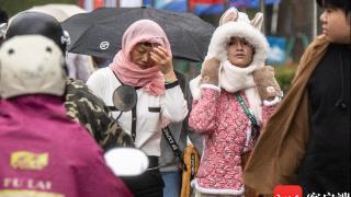 组图 | 冷空气叠加阴雨天 海口市民出行时“加码”装备