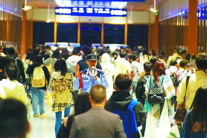 民警在车站大厅引导旅客有序乘车